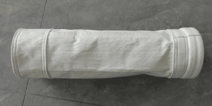 Industrial dust collector filter bag laid on workshop floor